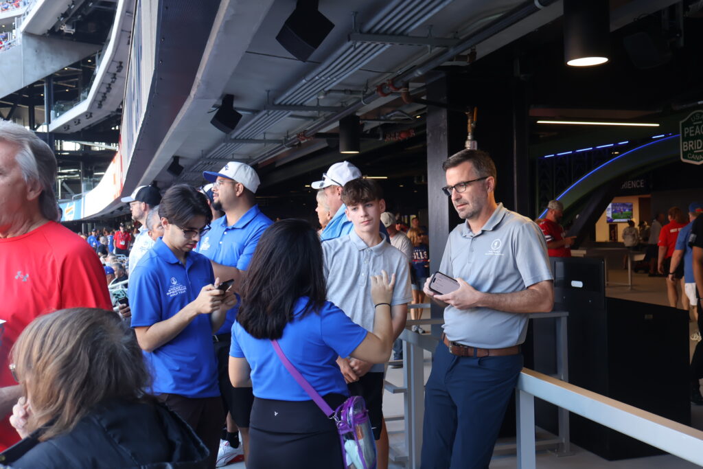 Attendees in Foundation polo shirts gathered on a stadium concourse