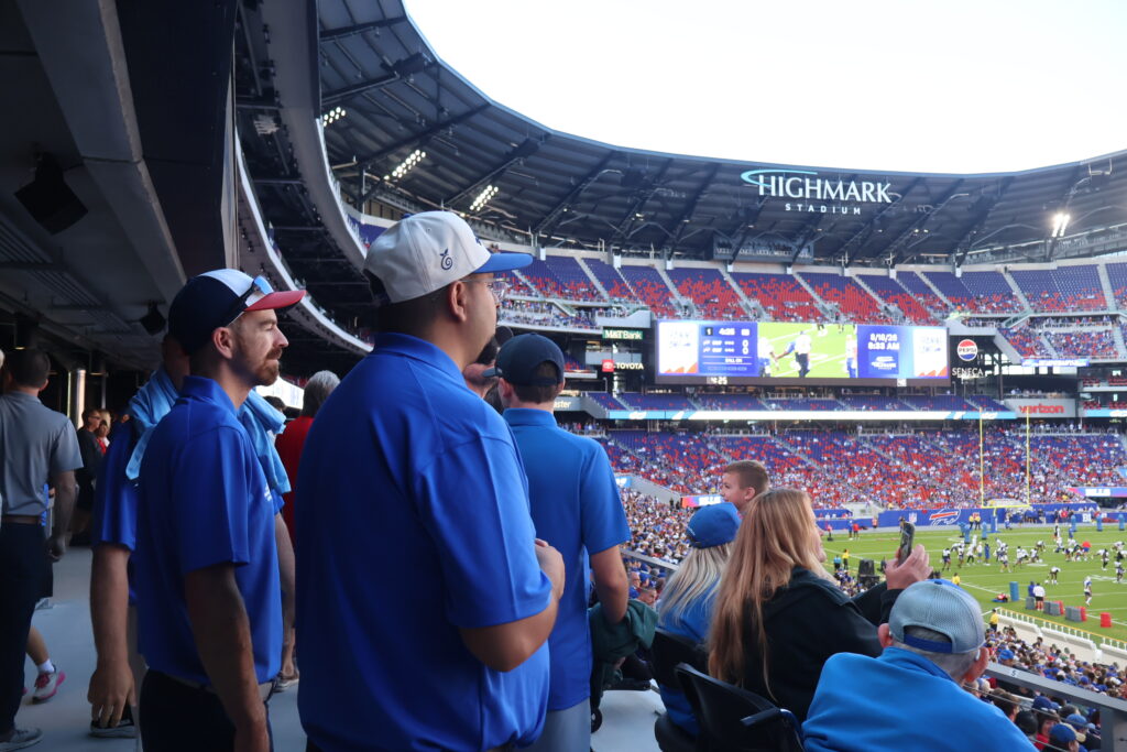 Attendees watching the field from a stadium walkway