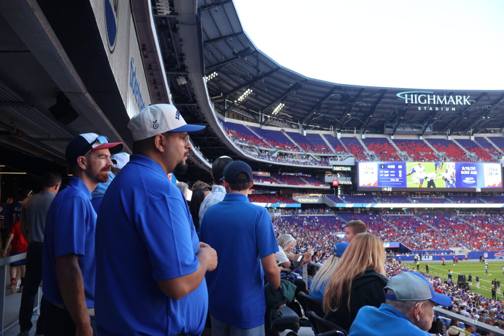 Two attendees looking out over the field from the stands
