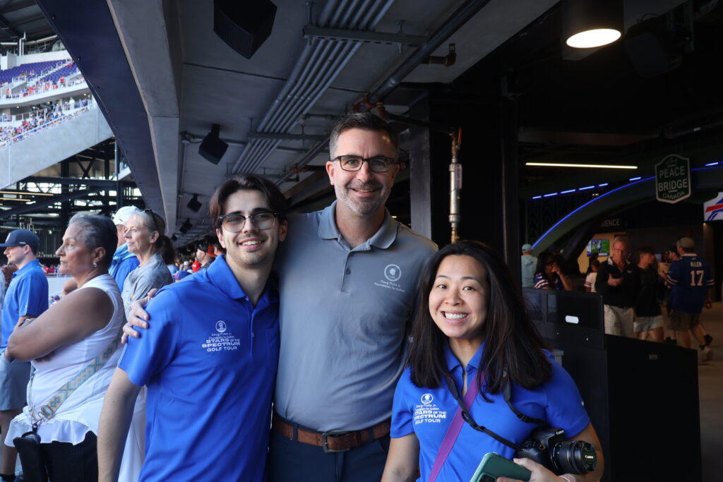 Three people posing together on the stadium concourse