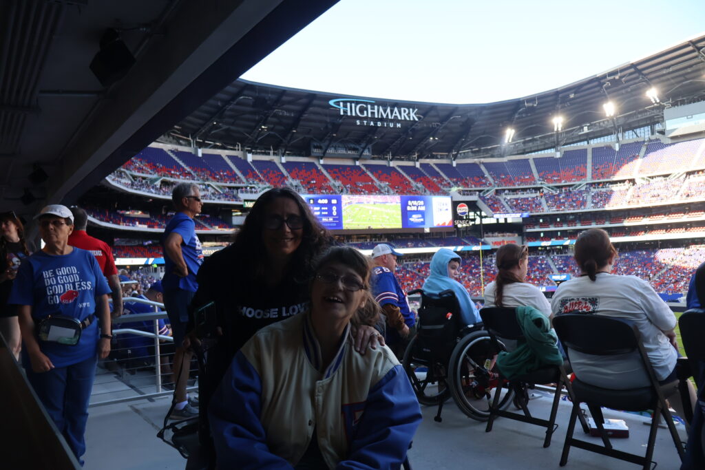 Two attendees in an accessible seating area, one using a wheelchair