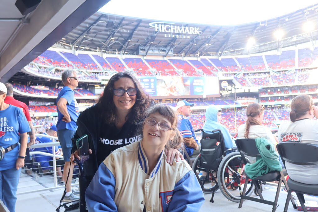 An attendee in a Choose Love jacket with a companion in the accessible seating area