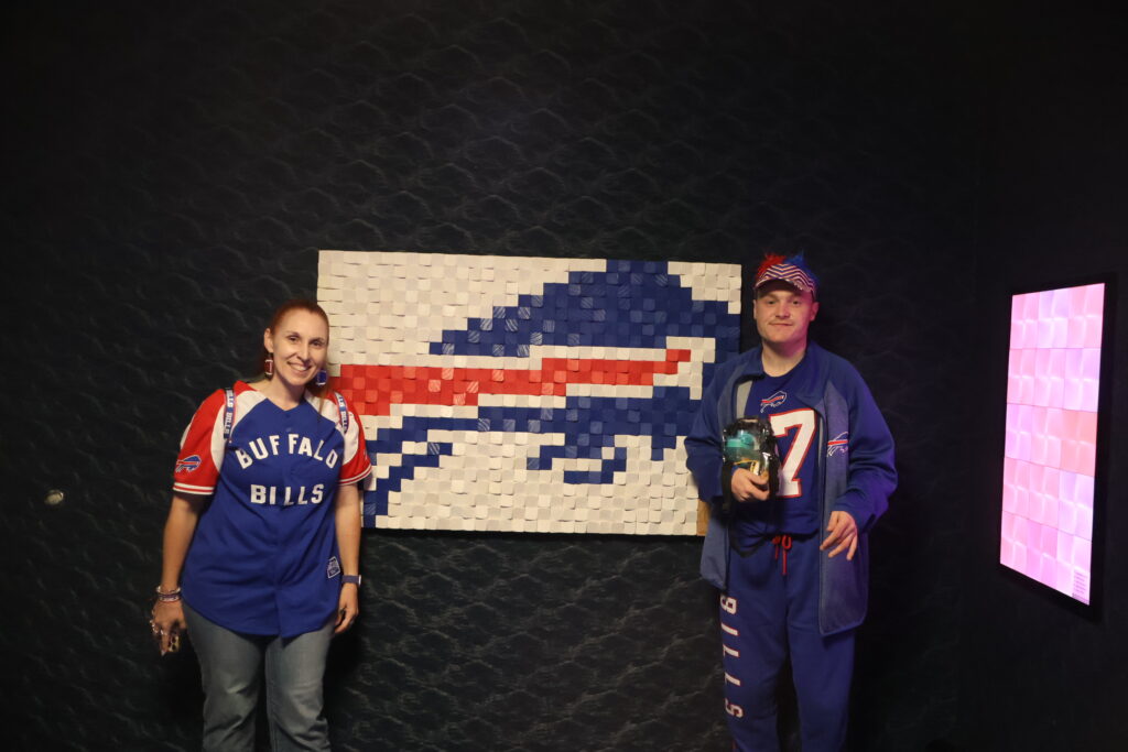 Attendees posing at the tactile Buffalo Bills logo mosaic