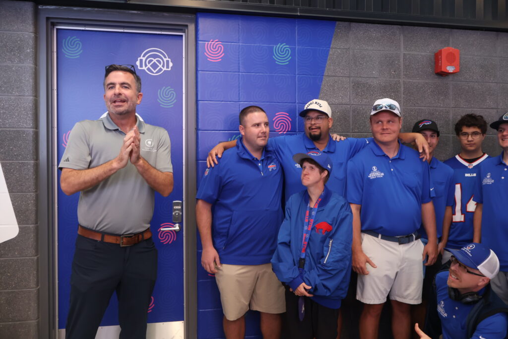 A host and attendees posing at the sensory room door