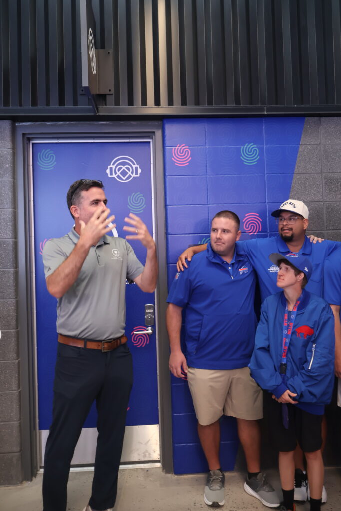 A host talking with attendees beside the sensory room entrance