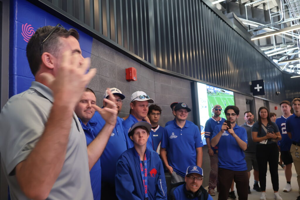 A host addressing attendees on the stadium concourse