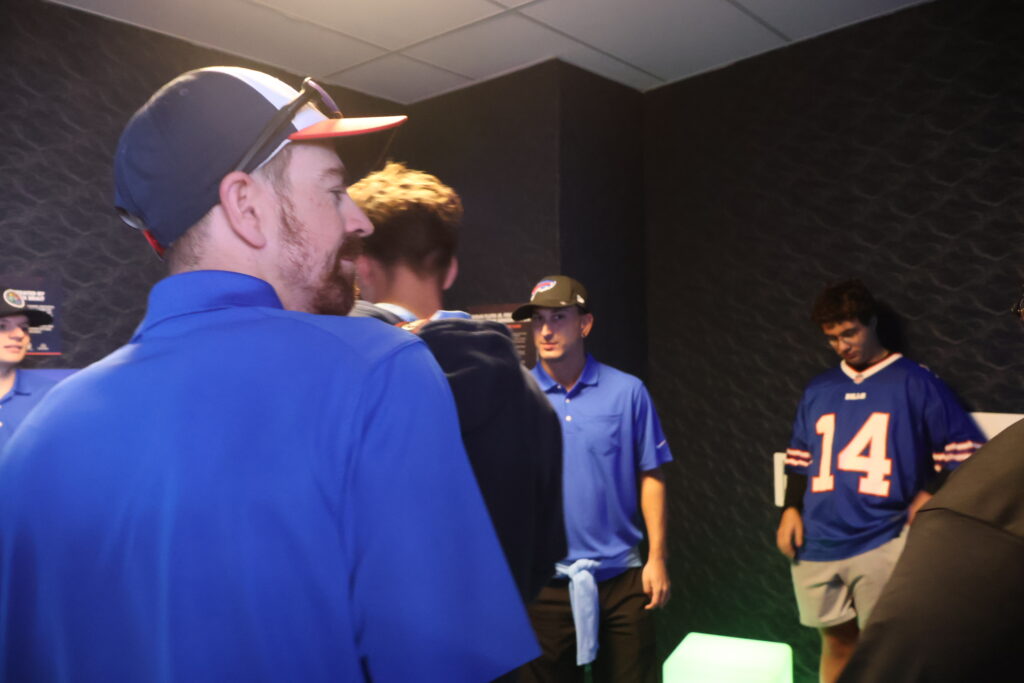 Visitors in Foundation polo shirts and Bills gear inside the dimly lit sensory room