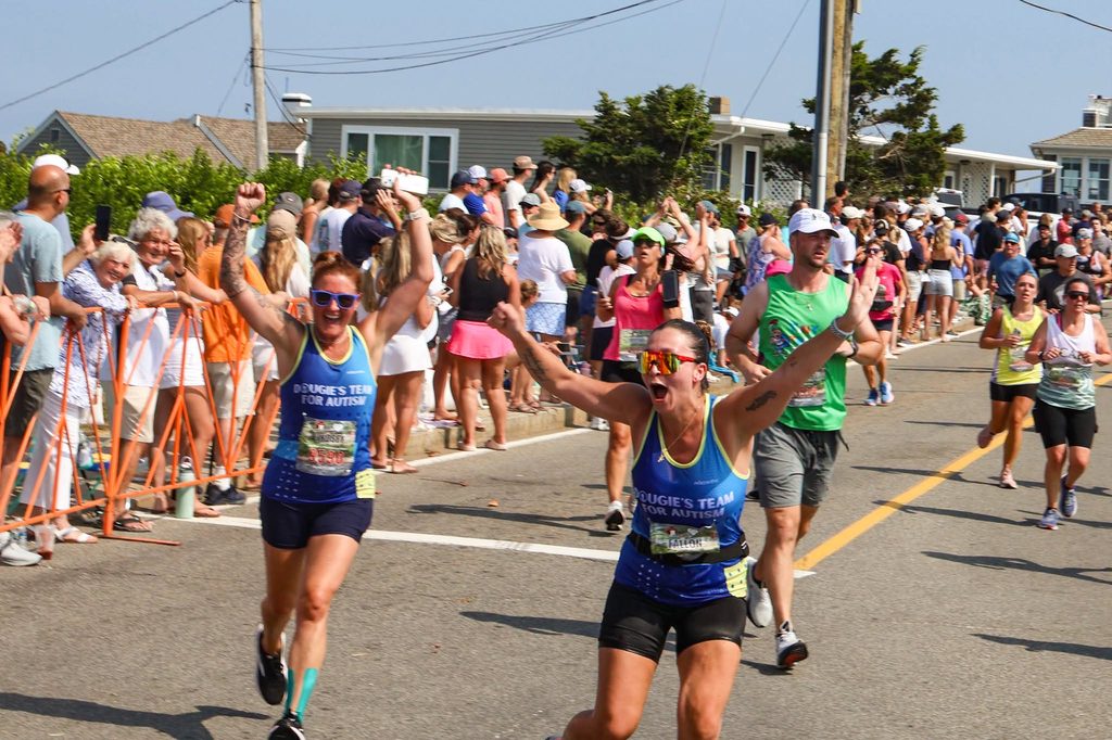 Two Dougie's Team for Autism runners celebrate with raised fists as they run side by side