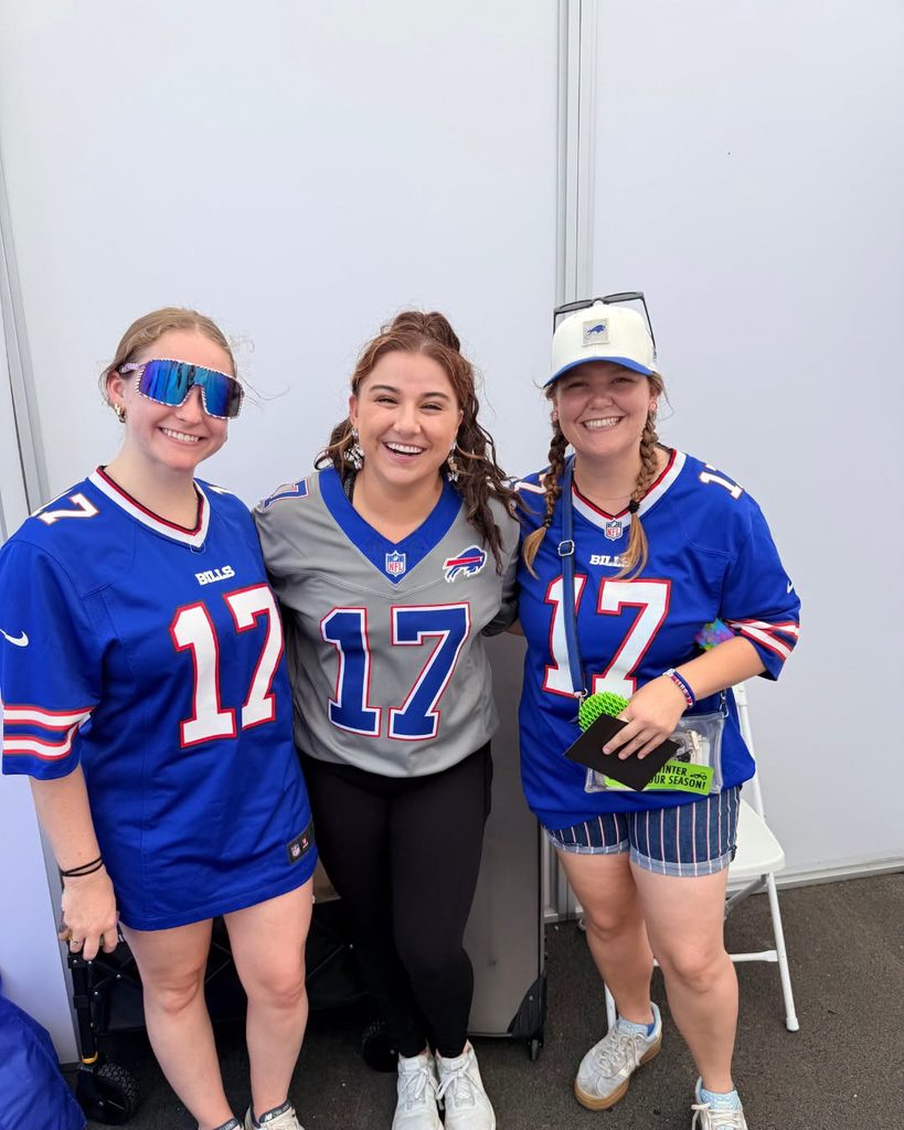 Three supporters in Buffalo Bills jerseys at the Doug Flutie Jr. Foundation booth